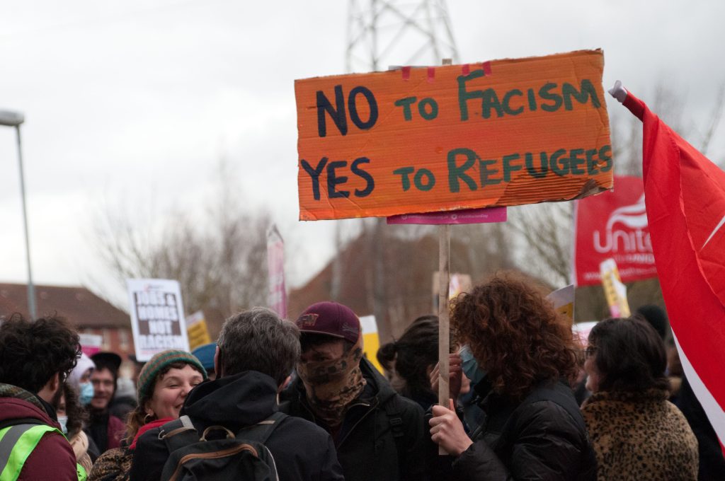 Ein Schild auf dem steht "No to Fascism, Yes to Refugees"